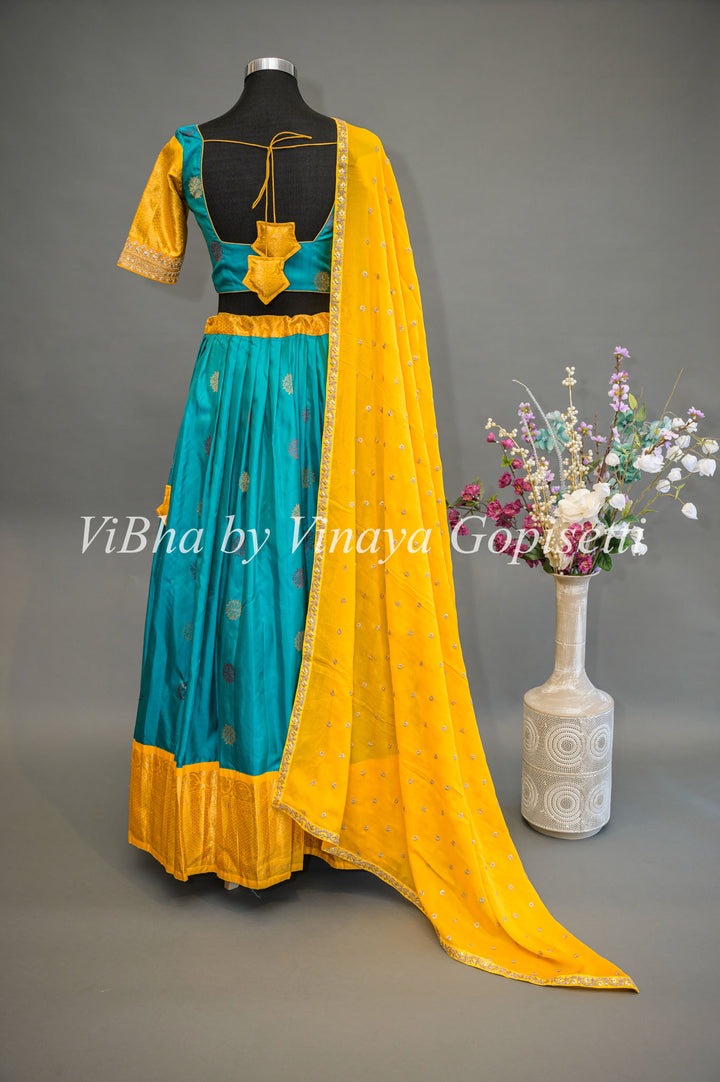 Teal Blue and Yellow Gadwal Silk Lehenga With Embroidered Hemline Of The Sleeves.
